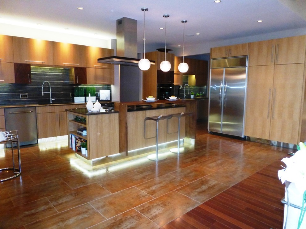 Esempio di una cucina minimal di medie dimensioni con ante lisce, ante in legno scuro, elettrodomestici in acciaio inossidabile e pavimento marrone
