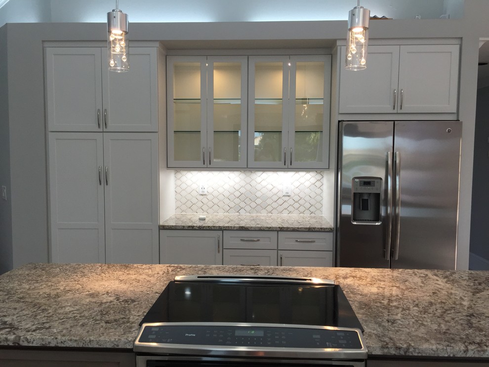 Exempel på ett modernt kök med öppen planlösning, med en undermonterad diskho, skåp i shakerstil, vita skåp, granitbänkskiva, vitt stänkskydd, stänkskydd i marmor, rostfria vitvaror, klinkergolv i porslin, en köksö och grått golv