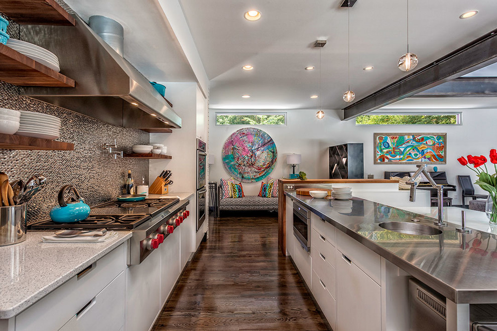 Photo of a large contemporary galley open plan kitchen in Other with a single-bowl sink, flat-panel cabinets, white cabinets, stainless steel worktops, metallic splashback, stainless steel appliances, dark hardwood flooring and an island.