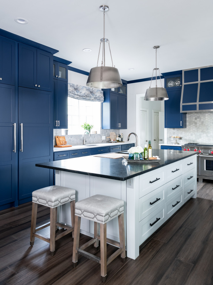 Idee per una cucina classica con lavello sottopiano, ante in stile shaker, ante blu, paraspruzzi grigio, elettrodomestici da incasso, pavimento in legno massello medio, pavimento marrone e top nero