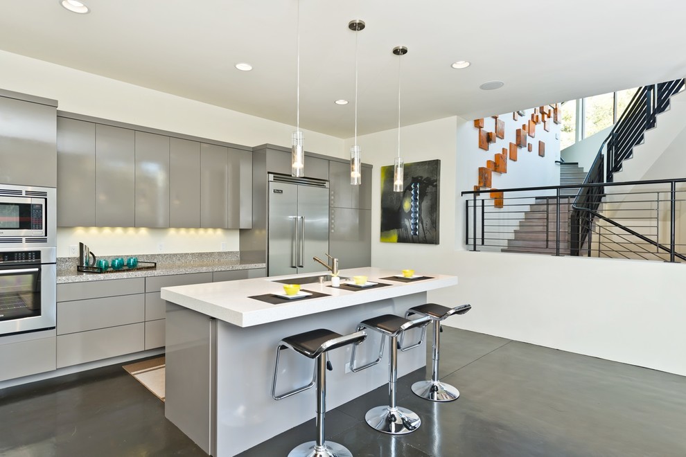 Foto de cocina contemporánea con armarios con paneles lisos, electrodomésticos de acero inoxidable, puertas de armario grises y fregadero bajoencimera