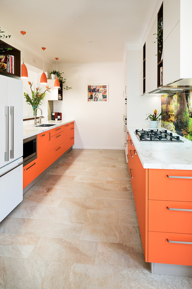Ispirazione per una cucina parallela moderna chiusa e di medie dimensioni con lavello a doppia vasca, ante lisce, ante arancioni, paraspruzzi bianco, paraspruzzi con lastra di vetro, elettrodomestici in acciaio inossidabile, pavimento in gres porcellanato e pavimento beige