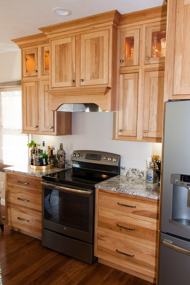 Medium sized rustic u-shaped kitchen/diner in Other with a submerged sink, shaker cabinets, light wood cabinets, granite worktops, stainless steel appliances, medium hardwood flooring and a breakfast bar.