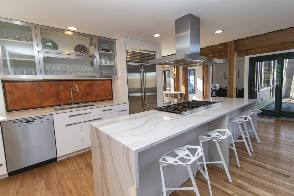 Eat-in kitchen - large modern galley medium tone wood floor eat-in kitchen idea in Baltimore with an undermount sink, flat-panel cabinets, white cabinets, quartz countertops, stainless steel appliances, an island and white countertops