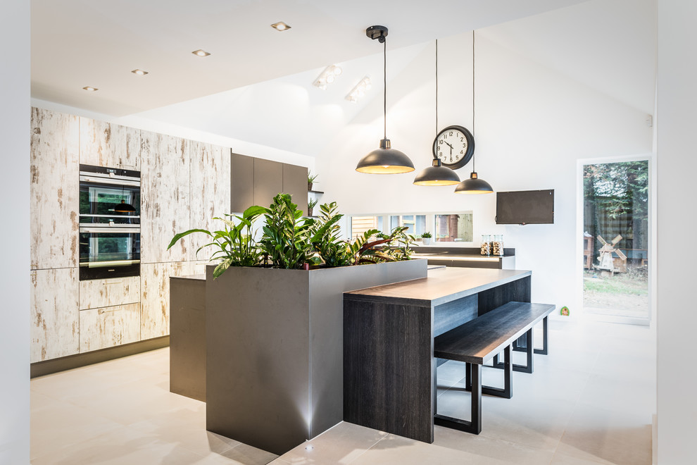 Photo of a large contemporary l-shaped kitchen/diner in Hampshire with a double-bowl sink, flat-panel cabinets, grey cabinets, engineered stone countertops, stainless steel appliances, ceramic flooring and an island.