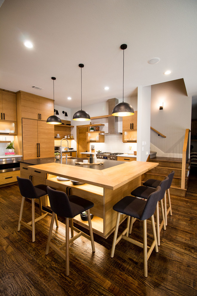 Example of a large danish dark wood floor and brown floor eat-in kitchen design in Dallas with flat-panel cabinets, light wood cabinets, granite countertops, white backsplash, subway tile backsplash, stainless steel appliances, an island and black countertops