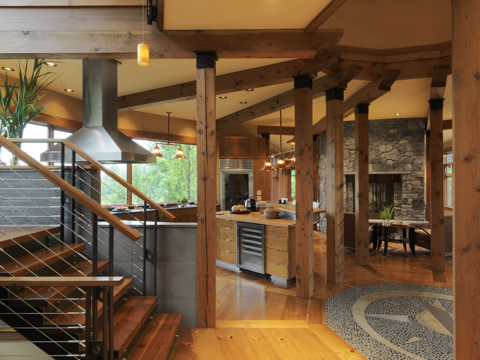 Пример оригинального дизайна: кухня-гостиная в современном стиле с плоскими фасадами, фасадами цвета дерева среднего тона, деревянной столешницей, техникой из нержавеющей стали и окном