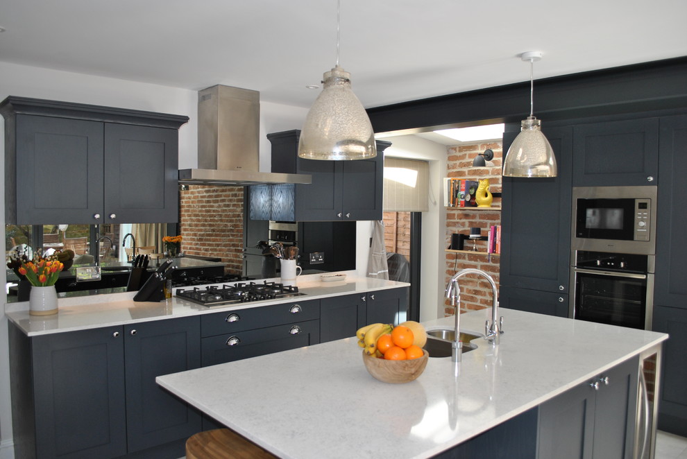 Modern shaker kitchen in dark slate blue against the brick wall