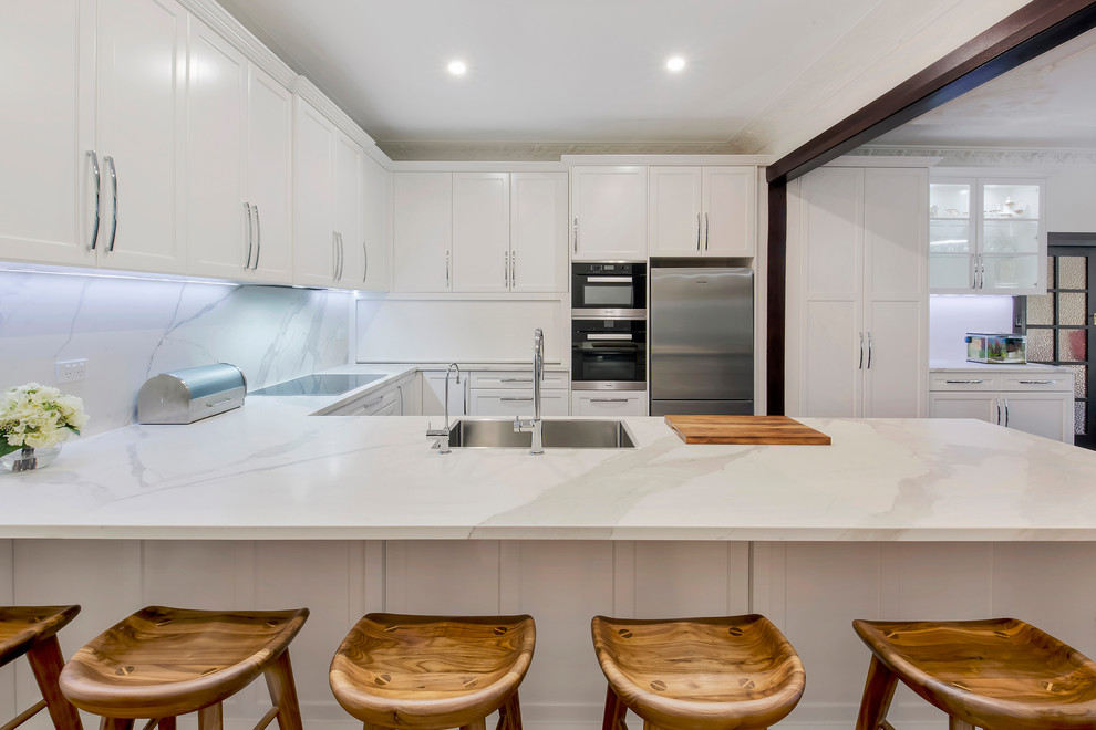 Kitchen pantry - large traditional u-shaped dark wood floor and brown floor kitchen pantry idea in Sydney with a single-bowl sink, shaker cabinets, white cabinets, quartz countertops, white backsplash, stone slab backsplash, stainless steel appliances, no island and white countertops