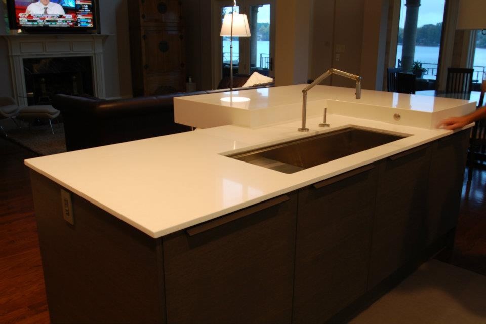 Foto di un cucina con isola centrale moderno con lavello sottopiano e top in quarzo composito