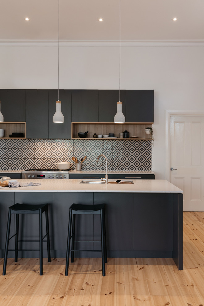 Moderne Küche mit Doppelwaschbecken, flächenbündigen Schrankfronten, bunter Rückwand, Küchengeräten aus Edelstahl, hellem Holzboden und Kücheninsel in Adelaide