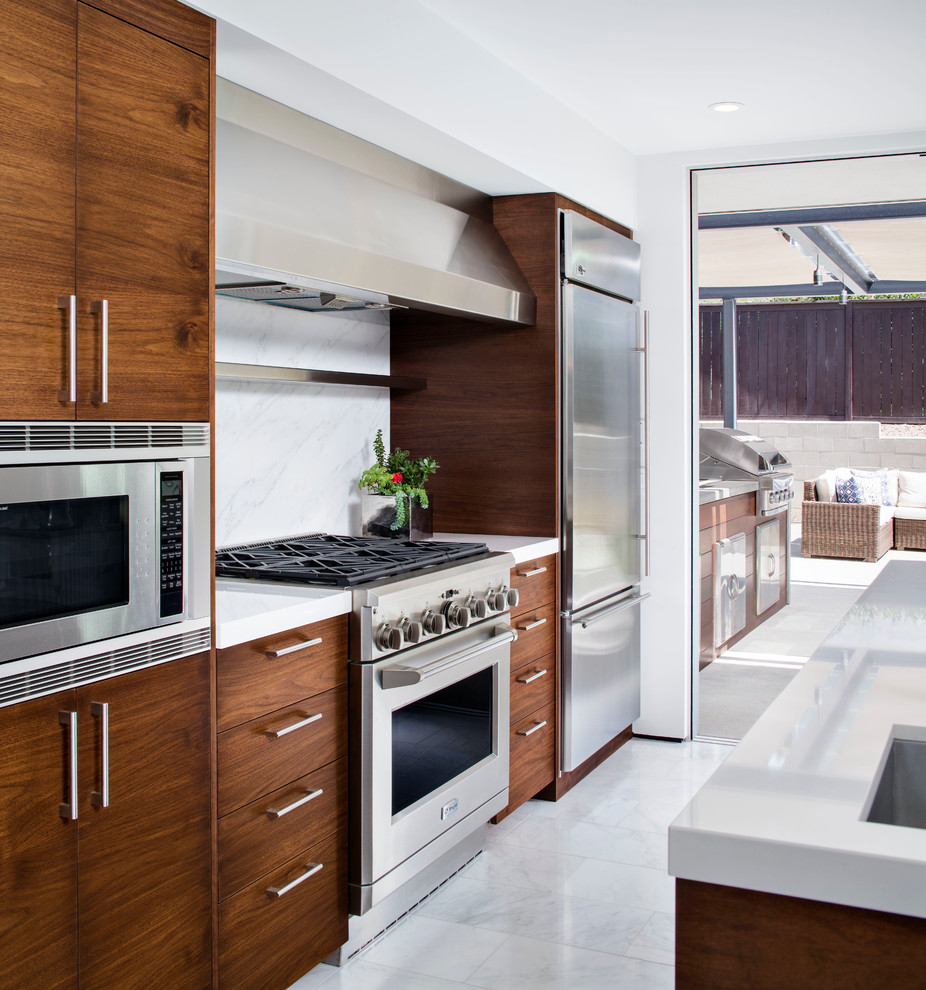Photo of an expansive contemporary u-shaped open plan kitchen in San Diego with a submerged sink, flat-panel cabinets, dark wood cabinets, white splashback, stone slab splashback, stainless steel appliances, marble flooring, an island and grey floors.