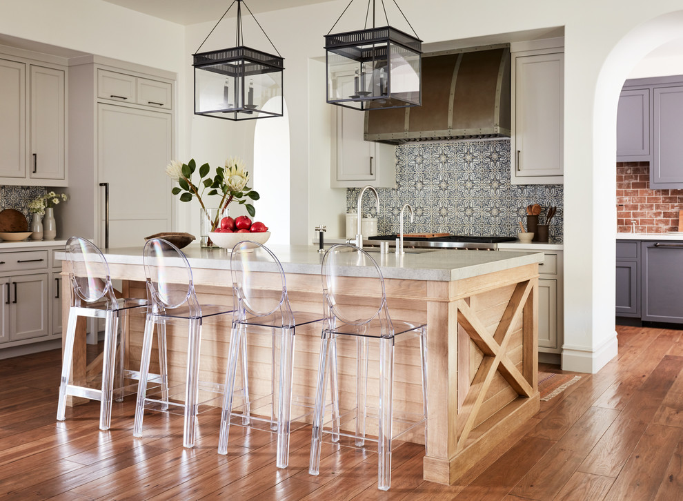 Inspiration for a mid-sized mediterranean l-shaped medium tone wood floor and brown floor kitchen remodel in San Francisco with quartzite countertops, ceramic backsplash, paneled appliances, an island, an undermount sink, recessed-panel cabinets, gray cabinets, blue backsplash and white countertops