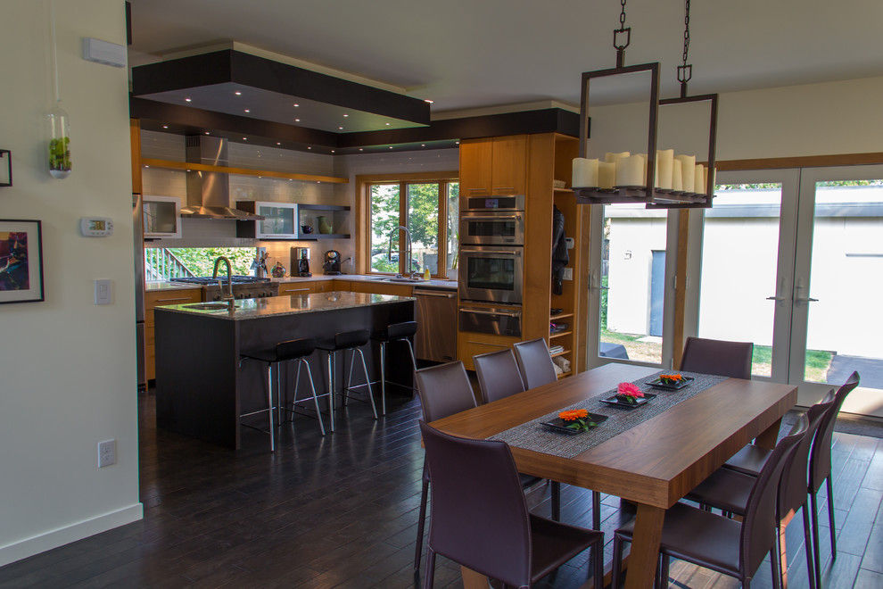 Mid-sized trendy u-shaped dark wood floor open concept kitchen photo in Minneapolis with flat-panel cabinets, light wood cabinets, stainless steel appliances, an island, an undermount sink, granite countertops, white backsplash and glass tile backsplash