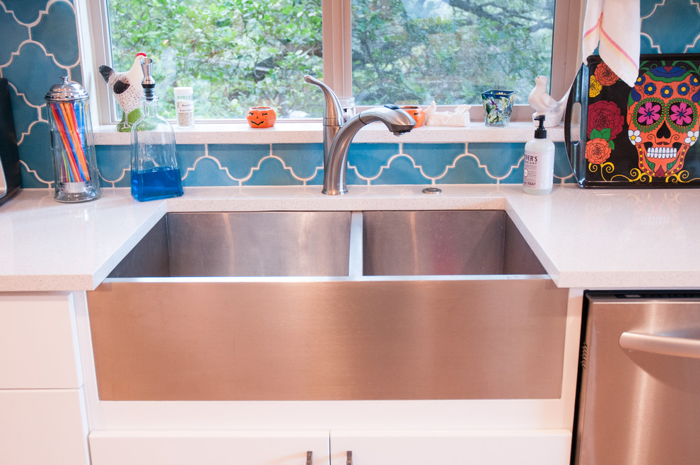 Inredning av ett modernt mellanstort kök och matrum, med en rustik diskho, släta luckor, vita skåp, blått stänkskydd, stänkskydd i keramik, rostfria vitvaror och en köksö