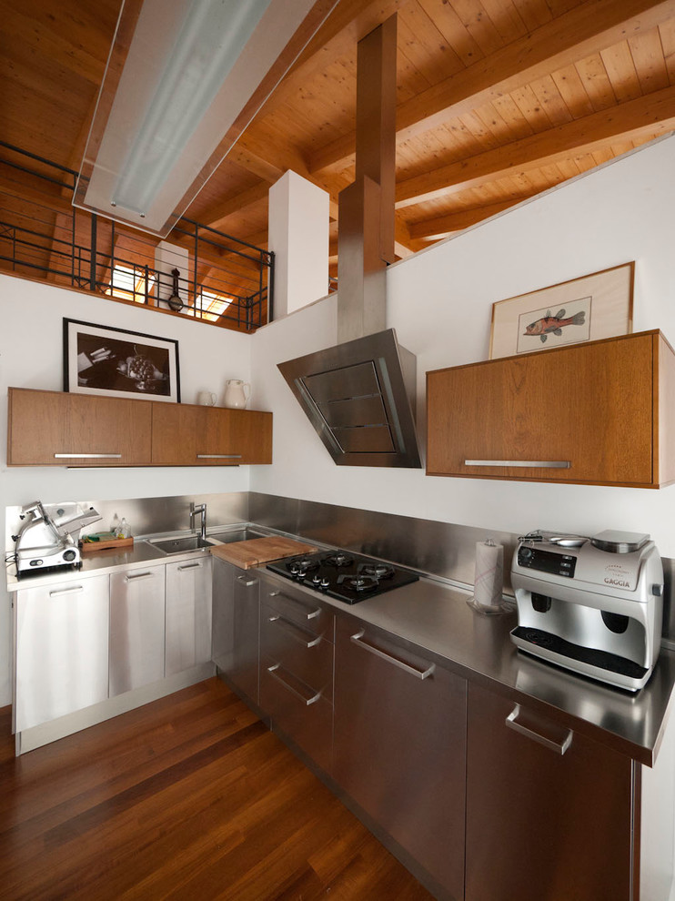 Exempel på ett modernt l-kök, med en integrerad diskho, släta luckor, skåp i rostfritt stål, bänkskiva i rostfritt stål, stänkskydd med metallisk yta, stänkskydd i metallkakel och rostfria vitvaror