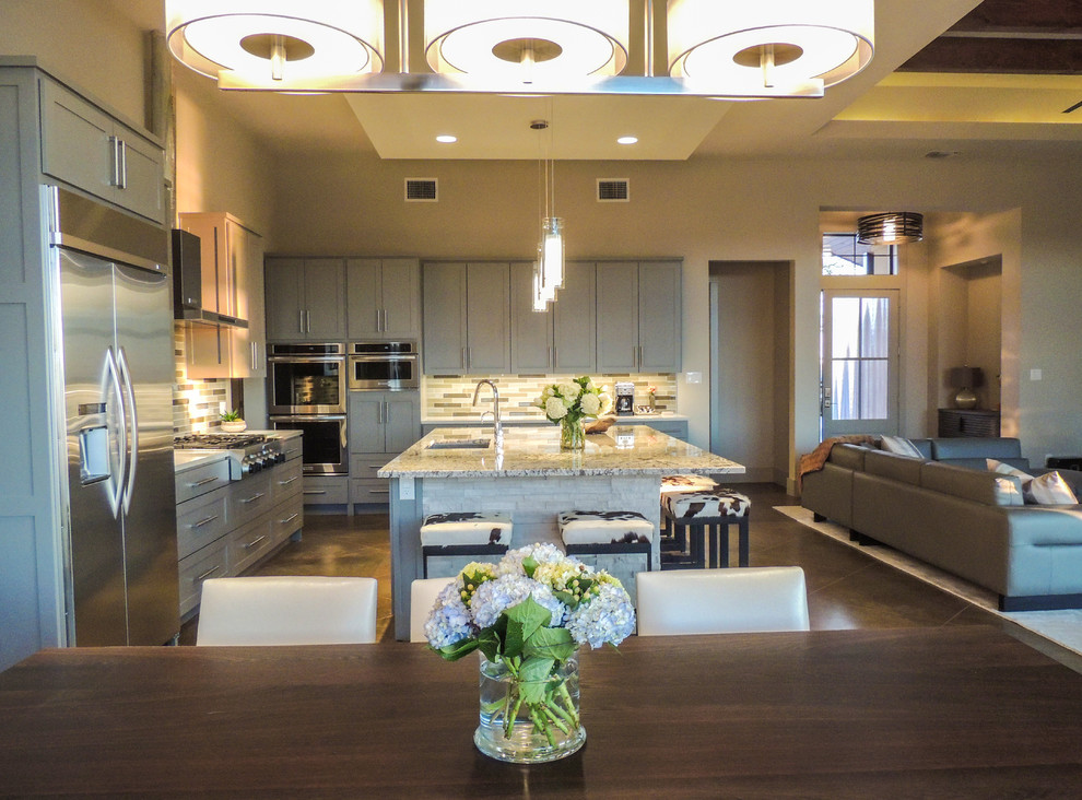 Exempel på ett stort modernt kök, med en undermonterad diskho, grå skåp, granitbänkskiva, flerfärgad stänkskydd, stänkskydd i glaskakel, rostfria vitvaror, betonggolv, en köksö och brunt golv