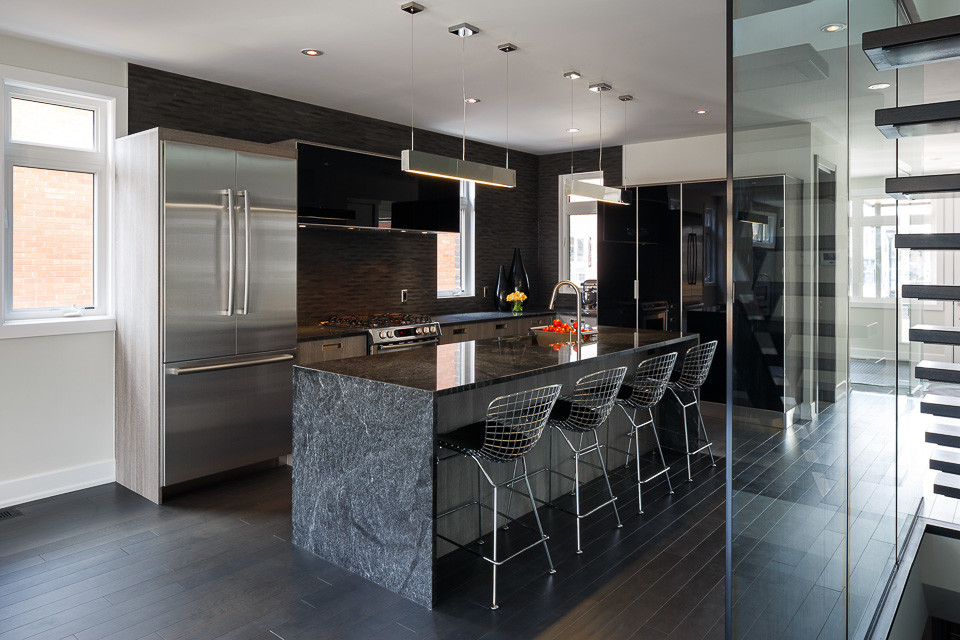 Inspiration for a mid-sized contemporary single-wall dark wood floor eat-in kitchen remodel in Ottawa with marble countertops, black backsplash, stainless steel appliances, an island and black cabinets