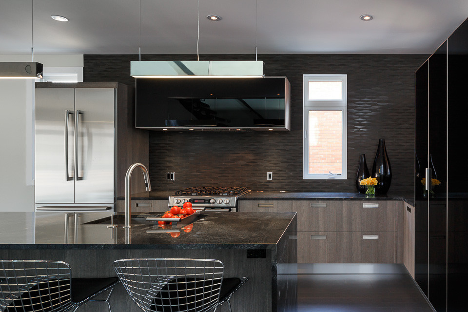 Foto di una cucina minimal di medie dimensioni con ante nere, top in marmo, paraspruzzi nero, elettrodomestici in acciaio inossidabile e parquet scuro