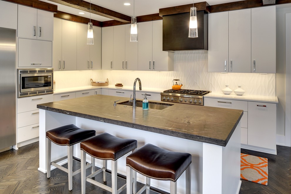 Moderne Küche in L-Form mit Unterbauwaschbecken, flächenbündigen Schrankfronten, weißen Schränken, Küchengeräten aus Edelstahl, dunklem Holzboden, Kücheninsel, braunem Boden und weißer Arbeitsplatte in Minneapolis