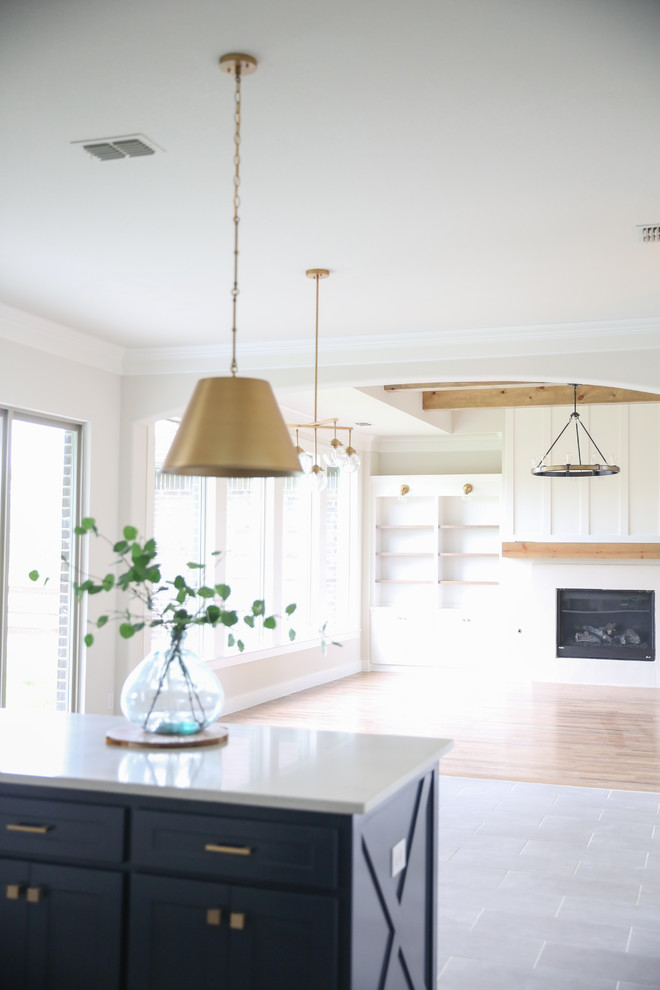 Photo of a medium sized classic l-shaped open plan kitchen in Dallas with a submerged sink, shaker cabinets, white cabinets, white splashback, stainless steel appliances, an island, grey floors, white worktops, quartz worktops, ceramic splashback and porcelain flooring.