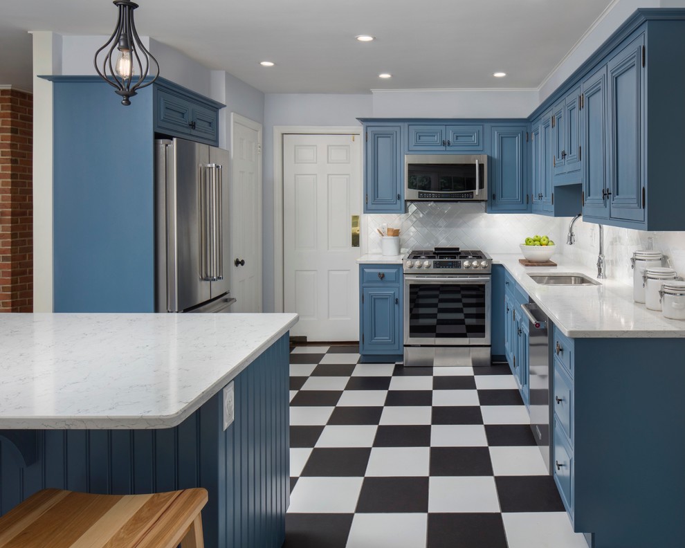 フィラデルフィアにある高級な広いトラディショナルスタイルのおしゃれなキッチン (アンダーカウンターシンク、青いキャビネット、クオーツストーンカウンター、白いキッチンパネル、シルバーの調理設備、磁器タイルの床、白いキッチンカウンター、落し込みパネル扉のキャビネット、マルチカラーの床) の写真