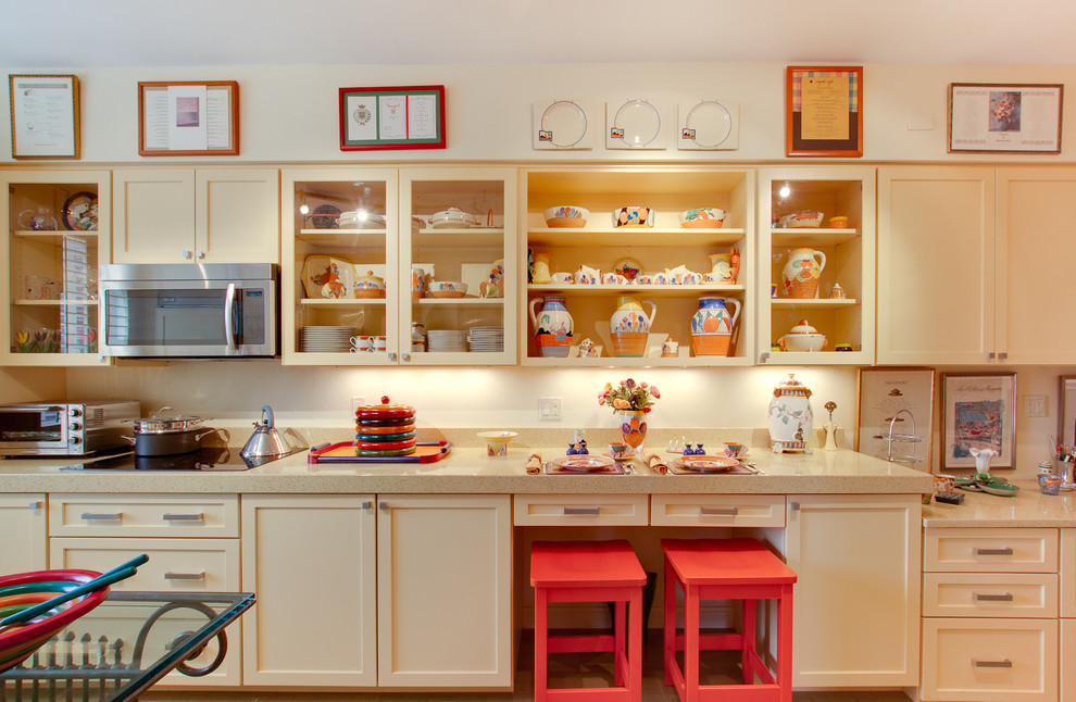 This is an example of an eclectic galley kitchen in DC Metro with glass-front cabinets and yellow cabinets.