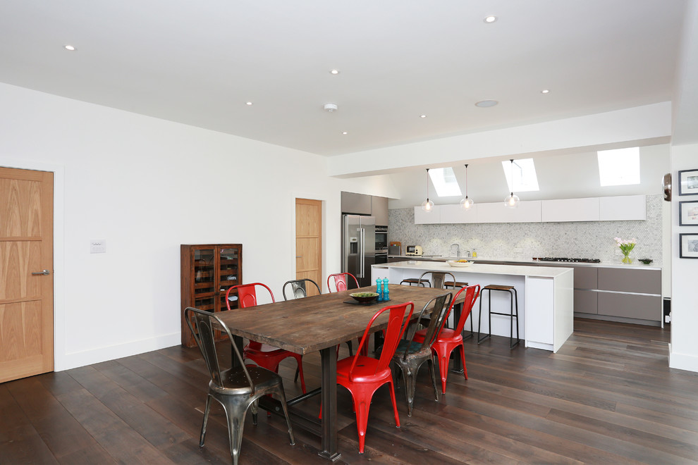 Moderne Wohnküche in L-Form mit grauen Schränken, Kücheninsel, flächenbündigen Schrankfronten, Rückwand aus Mosaikfliesen und dunklem Holzboden in London