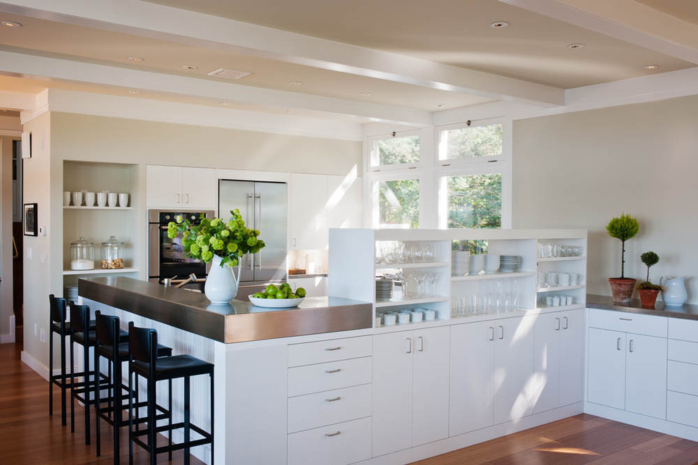 Inspiration for a timeless kitchen remodel in Burlington with white cabinets, flat-panel cabinets and stainless steel appliances