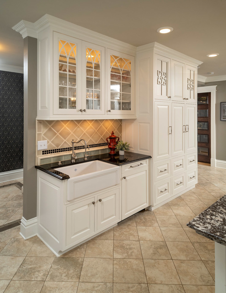Large ornate single-wall porcelain tile and gray floor open concept kitchen photo in Other with an undermount sink, raised-panel cabinets, white cabinets, brown backsplash, porcelain backsplash, stainless steel appliances, an island, black countertops and quartzite countertops