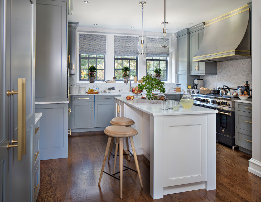 Inredning av ett klassiskt u-kök, med luckor med infälld panel, grå skåp, marmorbänkskiva, mellanmörkt trägolv, en köksö, flerfärgad stänkskydd, svarta vitvaror och orange golv