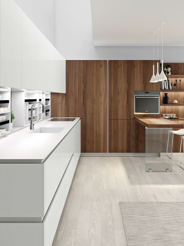 Design ideas for a medium sized modern single-wall open plan kitchen in San Francisco with a built-in sink, flat-panel cabinets, white cabinets, engineered stone countertops, stainless steel appliances, light hardwood flooring, brown floors and white worktops.