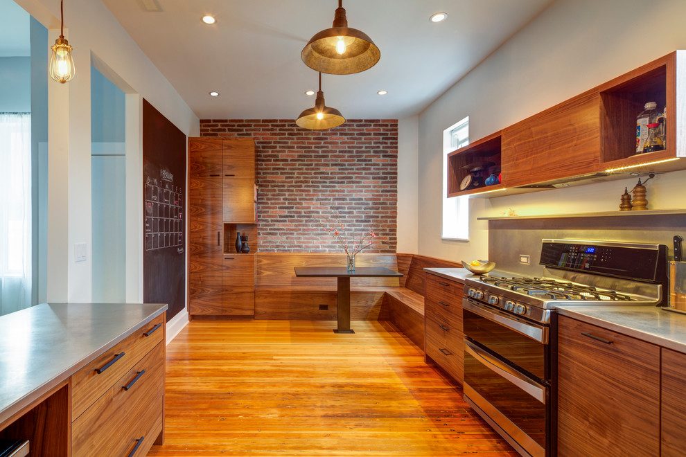 This is an example of a large modern l-shaped enclosed kitchen in Portland with a submerged sink, flat-panel cabinets, dark wood cabinets, stainless steel worktops, metallic splashback, stainless steel appliances, medium hardwood flooring and an island.