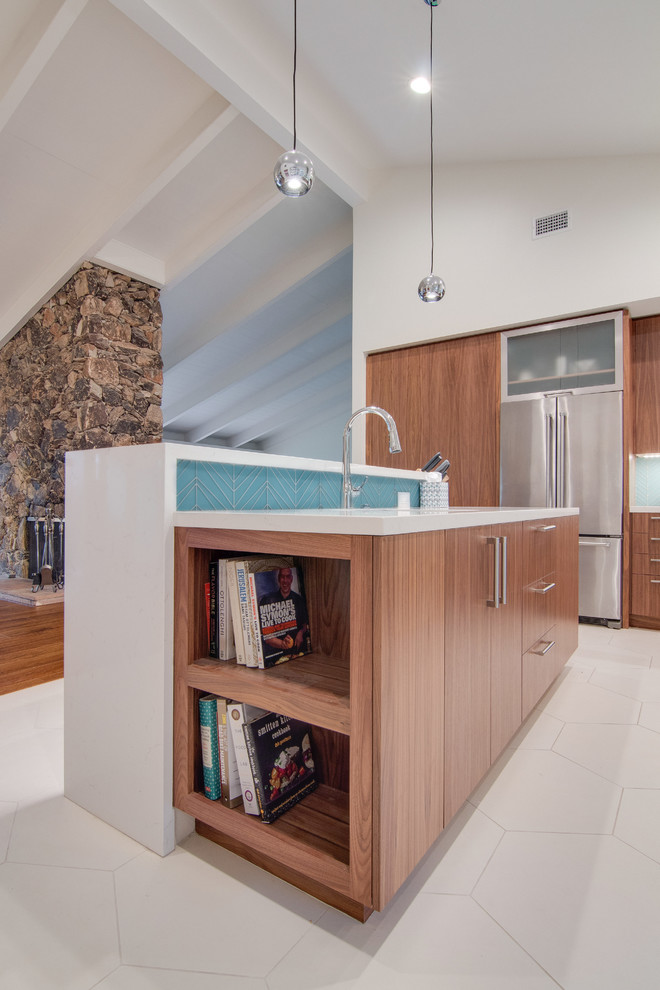 Foto di una grande cucina moderna con lavello sottopiano, ante lisce, ante in legno bruno, paraspruzzi blu, paraspruzzi con lastra di vetro, elettrodomestici in acciaio inossidabile, pavimento in gres porcellanato e 2 o più isole