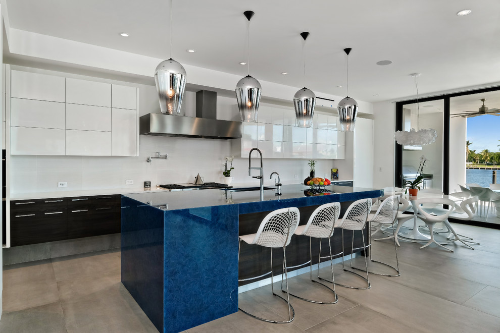 Imagen de cocina contemporánea con fregadero bajoencimera, armarios con paneles lisos, salpicadero blanco, una isla, suelo gris, encimeras azules y puertas de armario blancas