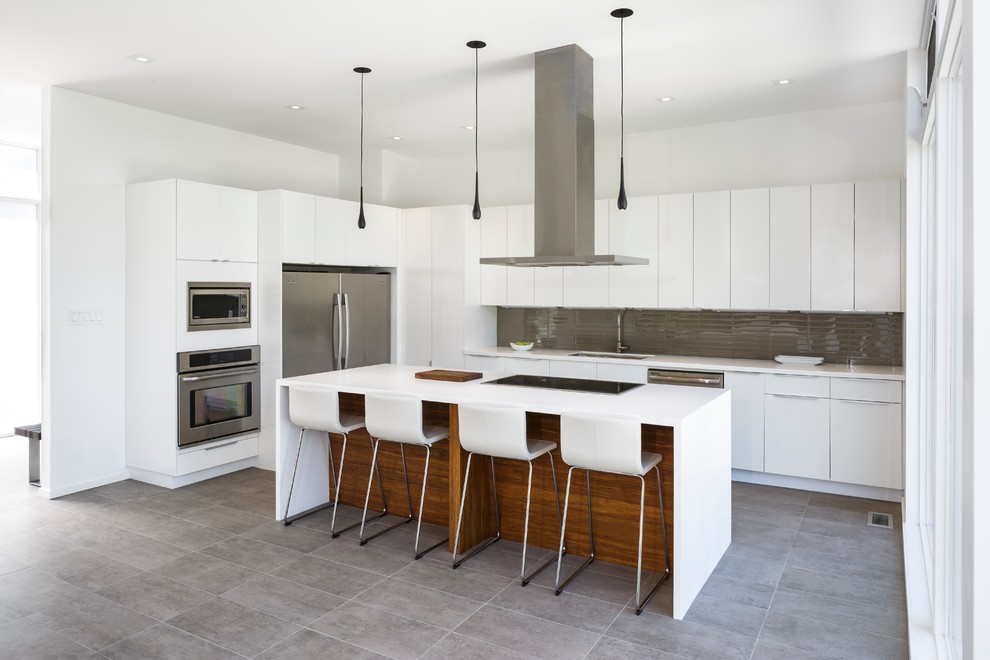 Modern inredning av ett mellanstort kök, med en undermonterad diskho, släta luckor, vita skåp, bänkskiva i koppar, grått stänkskydd, stänkskydd i glaskakel, rostfria vitvaror, betonggolv och en köksö