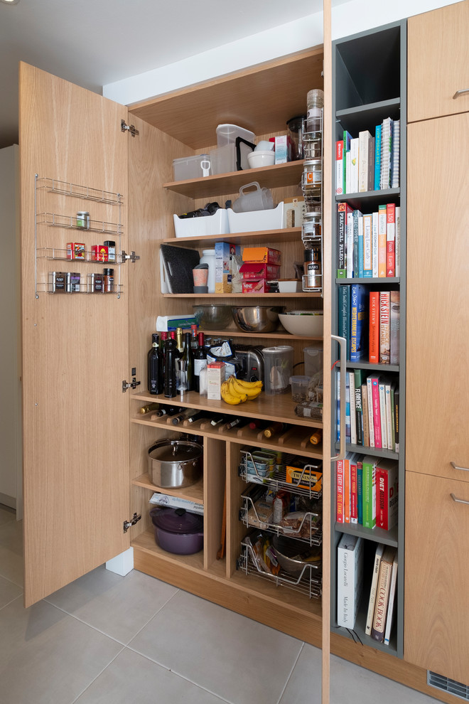 Photo of a small contemporary single-wall kitchen pantry in Cardiff with flat-panel cabinets, porcelain flooring, grey floors and light wood cabinets.