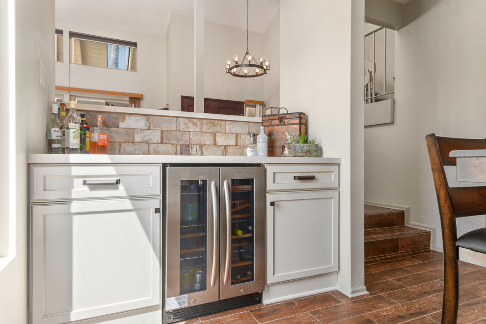 Idéer för ett litet rustikt vit kök, med en rustik diskho, skåp i shakerstil, vita skåp, bänkskiva i koppar, flerfärgad stänkskydd, stänkskydd i tegel, rostfria vitvaror, klinkergolv i keramik, en köksö och brunt golv