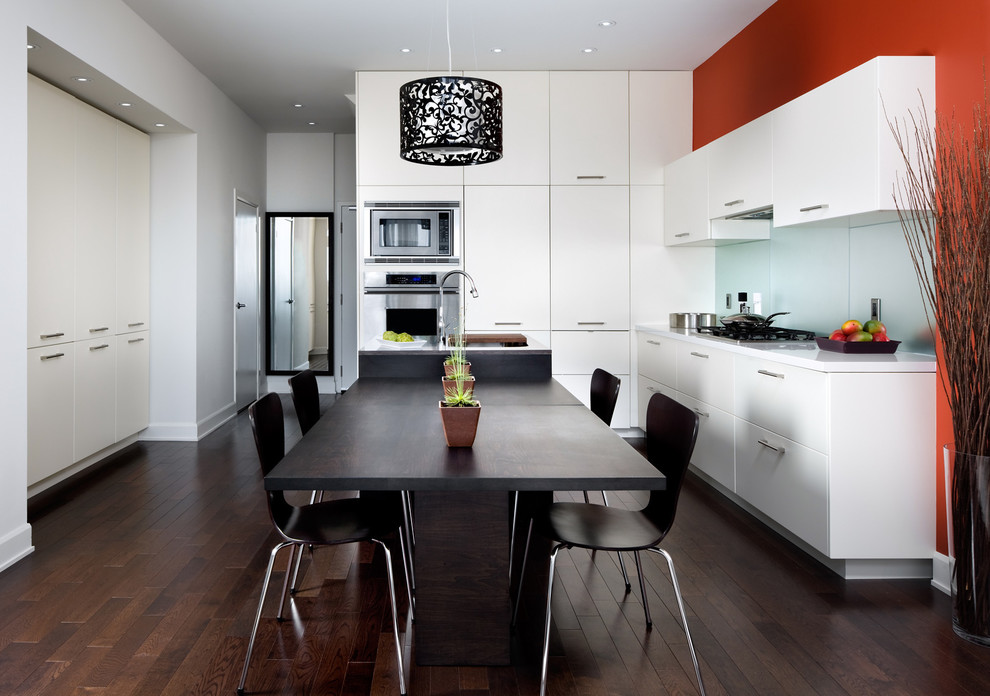 トロントにあるコンテンポラリースタイルのおしゃれなキッチン (フラットパネル扉のキャビネット、シルバーの調理設備、ガラス板のキッチンパネル) の写真