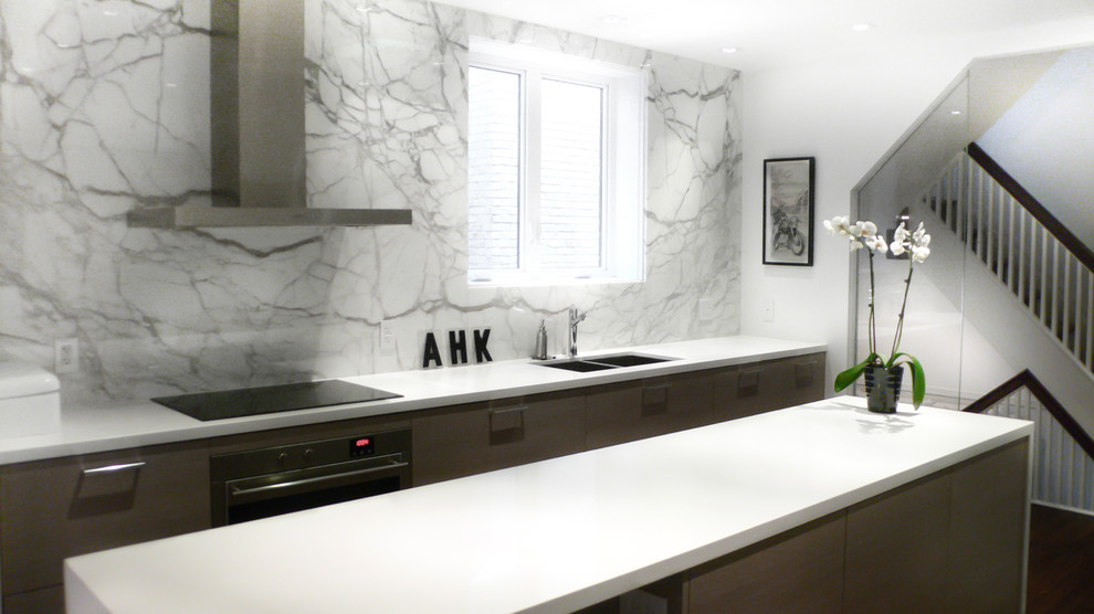 Inspiration for a mid-sized contemporary l-shaped medium tone wood floor and brown floor open concept kitchen remodel in Toronto with a double-bowl sink, quartz countertops, white backsplash, flat-panel cabinets, gray cabinets, stone slab backsplash, paneled appliances and an island