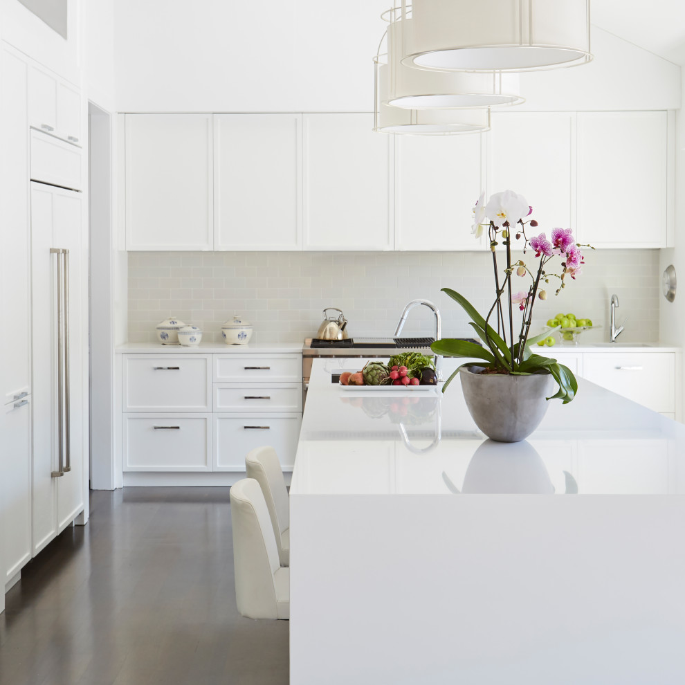 Diseño de cocina clásica renovada con salpicadero blanco, electrodomésticos de acero inoxidable, una isla y vigas vistas