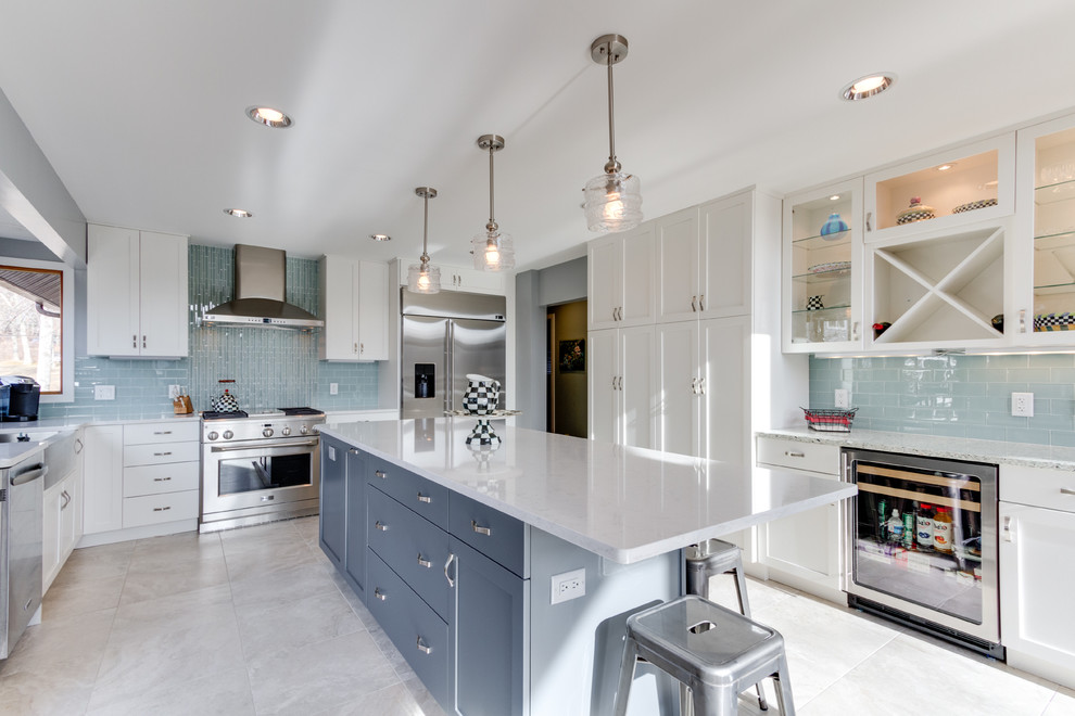 Example of a transitional u-shaped eat-in kitchen design in DC Metro with a farmhouse sink, shaker cabinets, white cabinets, quartz countertops, blue backsplash, glass tile backsplash and stainless steel appliances