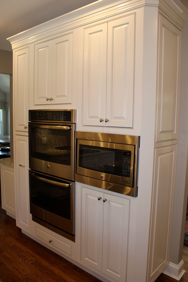 Idéer för ett mellanstort modernt kök, med en undermonterad diskho, luckor med upphöjd panel, vita skåp, granitbänkskiva, flerfärgad stänkskydd, stänkskydd i mosaik, rostfria vitvaror och en köksö