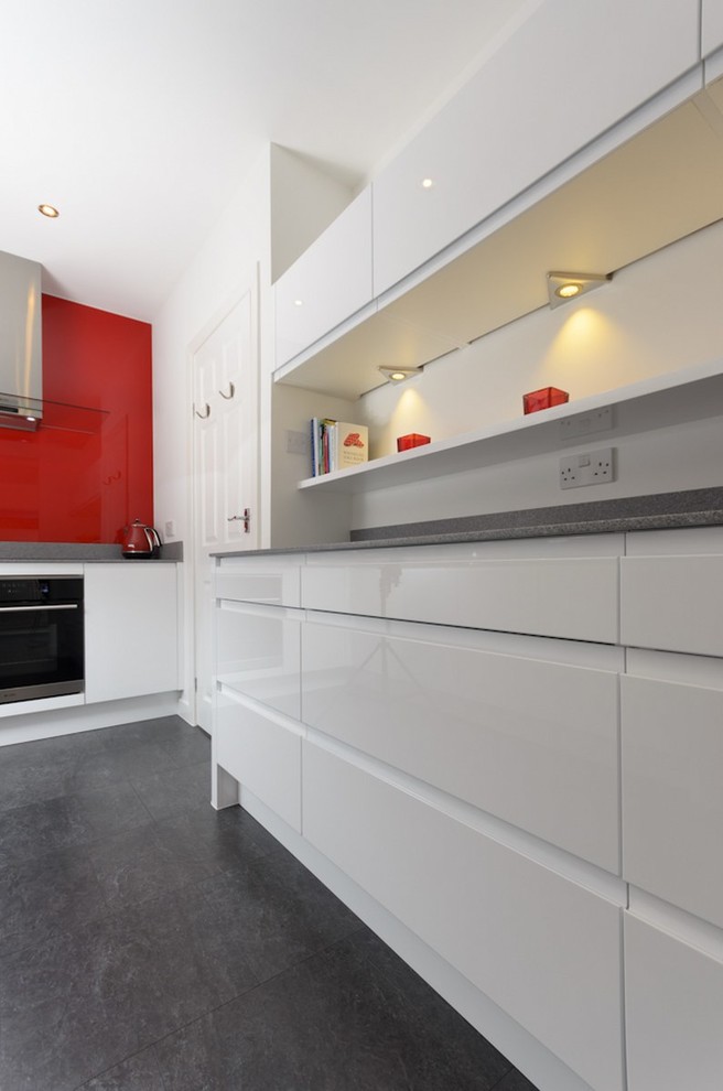 Foto di una cucina contemporanea di medie dimensioni con ante lisce, ante bianche, paraspruzzi rosso, nessuna isola e top grigio