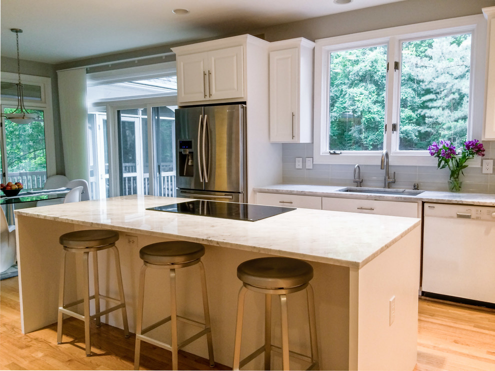 Foto på ett funkis kök, med marmorbänkskiva, en köksö, en undermonterad diskho, vitt stänkskydd och stänkskydd i glaskakel