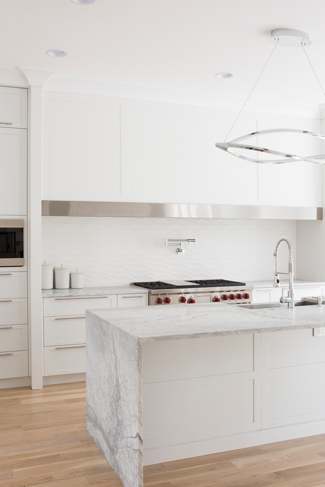 Exempel på ett stort modernt kök, med en rustik diskho, luckor med infälld panel, vita skåp, marmorbänkskiva, vitt stänkskydd, stänkskydd i keramik, rostfria vitvaror, ljust trägolv och en köksö