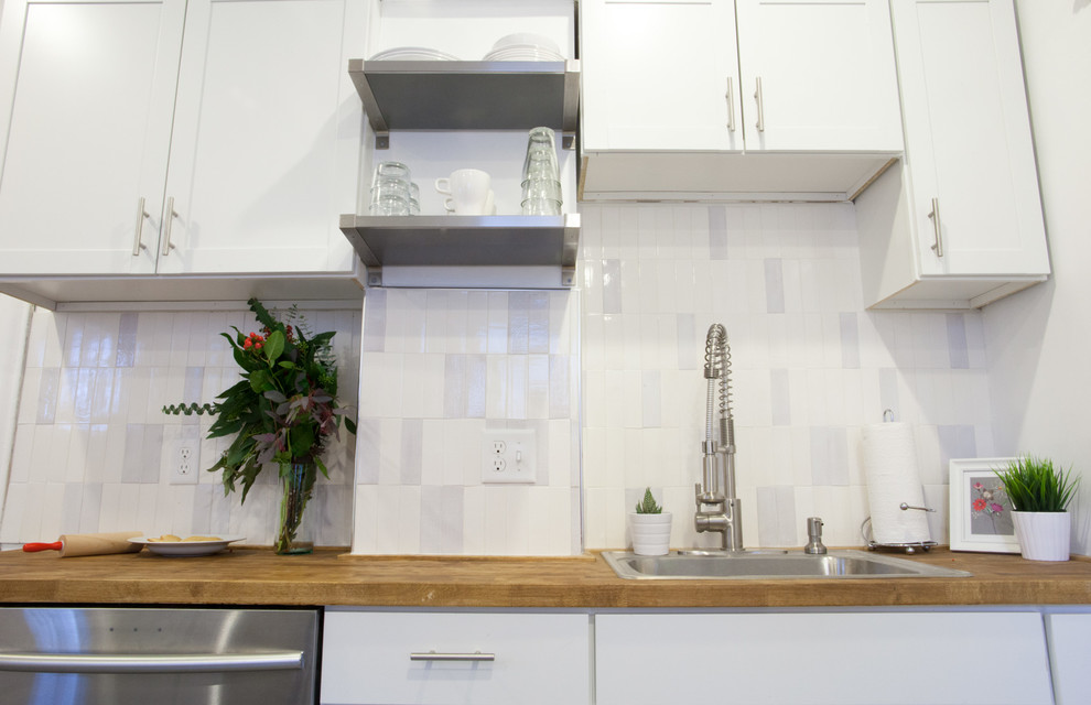 Exempel på ett avskilt, mellanstort modernt l-kök, med en enkel diskho, vita skåp, träbänkskiva, vitt stänkskydd, stänkskydd i keramik, rostfria vitvaror, klinkergolv i porslin och skåp i shakerstil