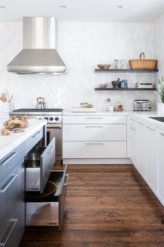Immagine di una cucina minimal con lavello sottopiano, ante lisce, ante bianche, paraspruzzi bianco, elettrodomestici in acciaio inossidabile, parquet scuro, pavimento marrone e top bianco