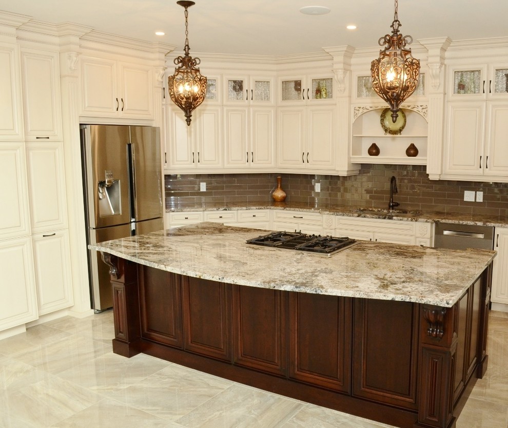 Klassisk inredning av ett stort l-kök, med en undermonterad diskho, luckor med upphöjd panel, vita skåp, granitbänkskiva, brunt stänkskydd, stänkskydd i glaskakel, rostfria vitvaror, marmorgolv och en köksö