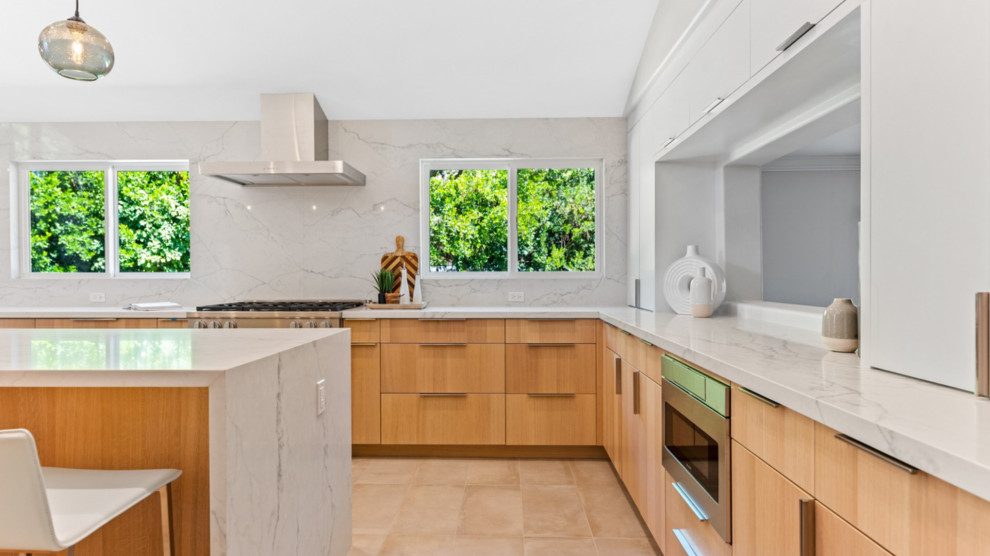 Large minimalist u-shaped porcelain tile and beige floor eat-in kitchen photo in Los Angeles with an undermount sink, light wood cabinets, quartz countertops, white backsplash, stainless steel appliances, an island and white countertops